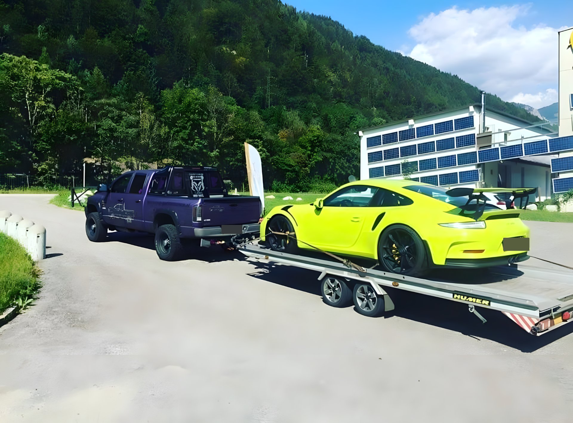 GMAPT Autotransport: Pickup mit Autotransport-Anhänger und verladenem Porsche in den österreichischen Alpen